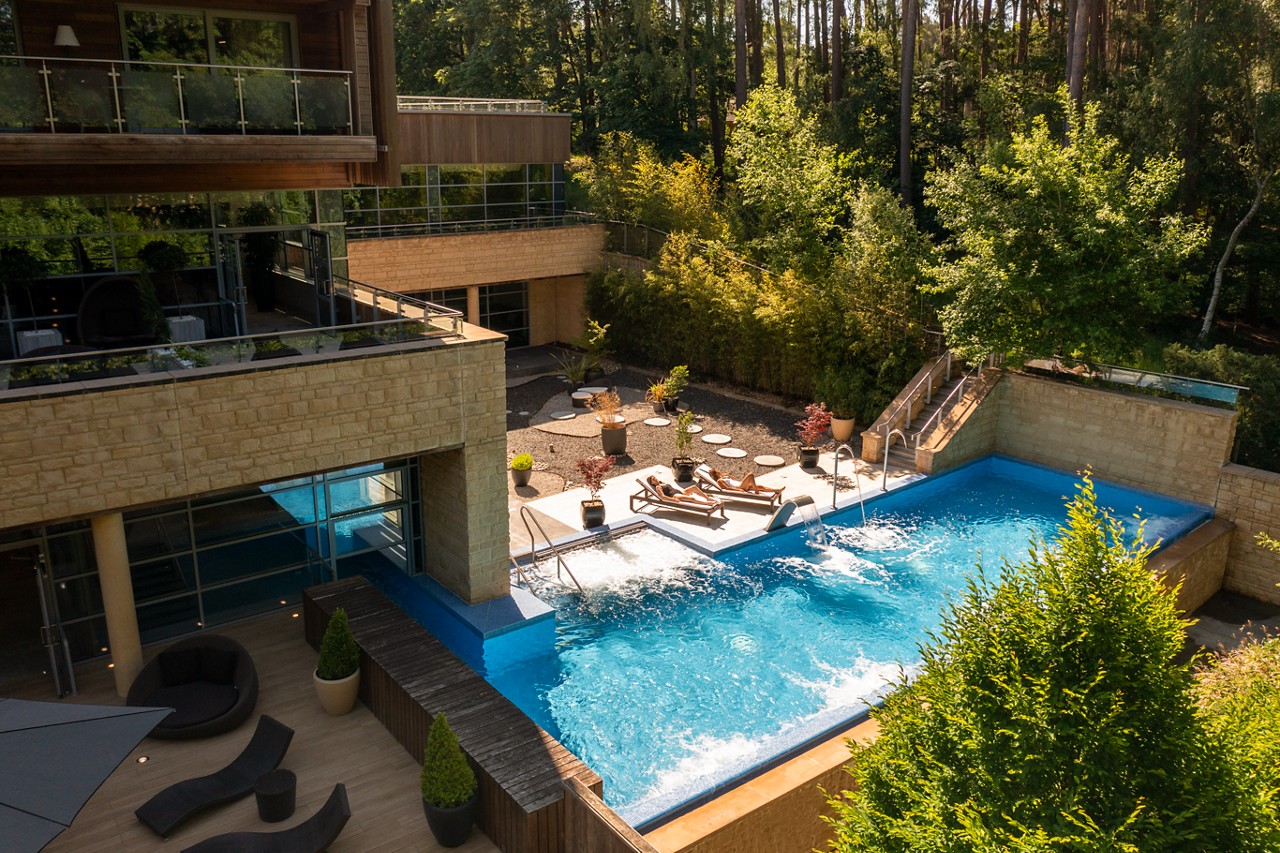 Outdoor Pool and sun loungers surrounded by the forest.